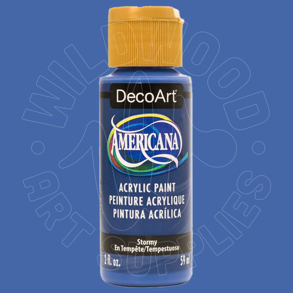 A bottle of DecoArt Americana acrylic paint in the color 'Stormy', featuring a dark blue body, a mustard yellow cap, and a white and blue label, set against a solid blue background with a faint watermark.
