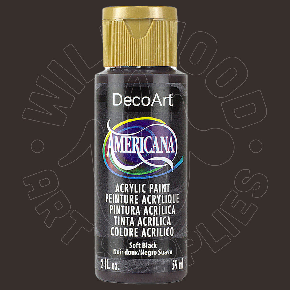 A bottle of DecoArt Americana Soft Black acrylic paint with a gold cap, shown against a dark brown background with a faint watermark.