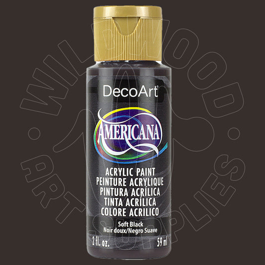 A bottle of DecoArt Americana Soft Black acrylic paint with a gold cap, shown against a dark brown background with a faint watermark.