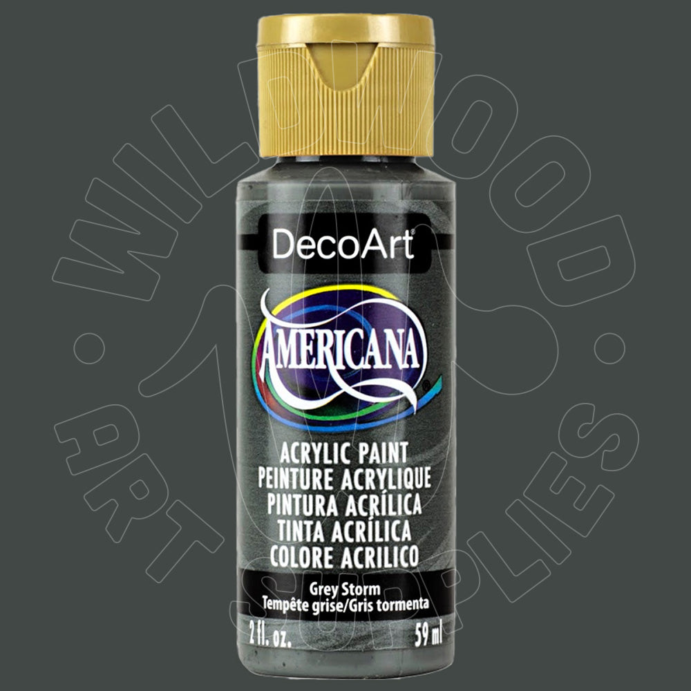 A bottle of DecoArt Americana acrylic paint in the color Grey Storm, featuring a gold cap and a black label with multicolor accents, set against a dark gray background with a faint watermark.