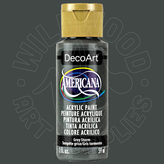 A bottle of DecoArt Americana acrylic paint in the color Grey Storm, featuring a gold cap and a black label with multicolor accents, set against a dark gray background with a faint watermark.