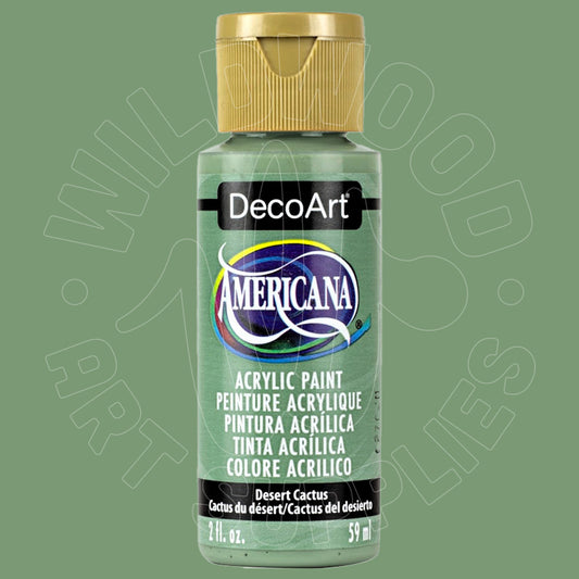 A bottle of DecoArt Americana acrylic paint in the color 'Desert Cactus' against a solid sage green background. The bottle has a metallic gold cap and a light green label with a prominent blue and white logo.