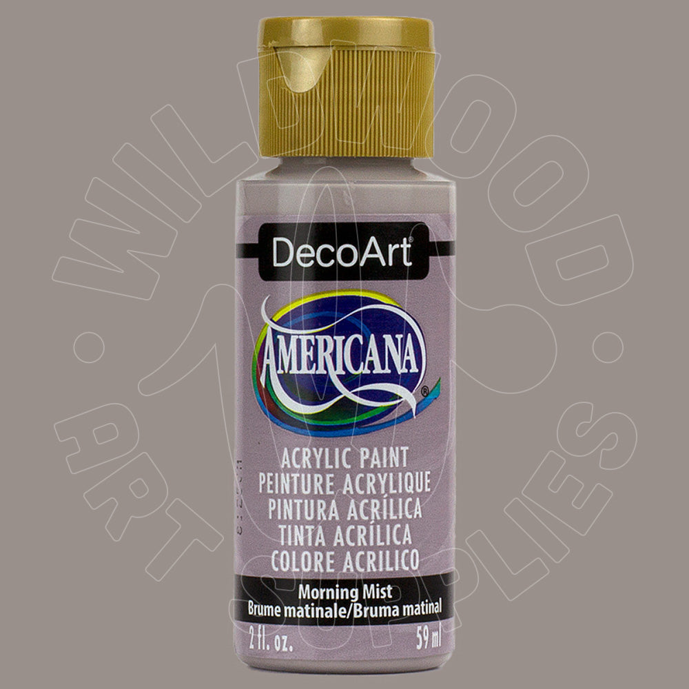 A bottle of DecoArt Americana acrylic paint in the color 'Morning Mist' with a metallic gold cap, shown against a solid taupe-gray background.