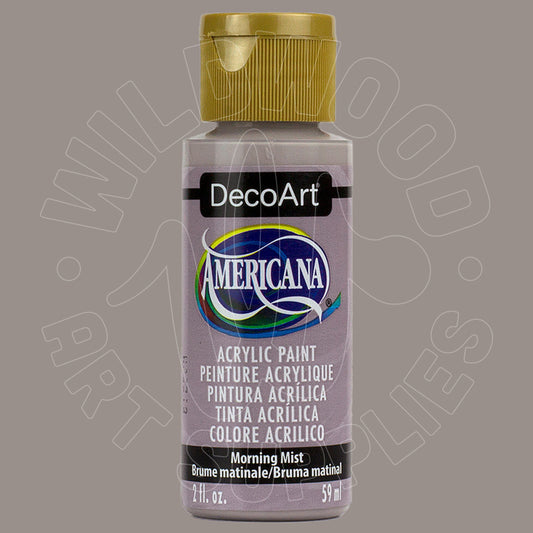 A bottle of DecoArt Americana acrylic paint in the color 'Morning Mist' with a metallic gold cap, shown against a solid taupe-gray background.