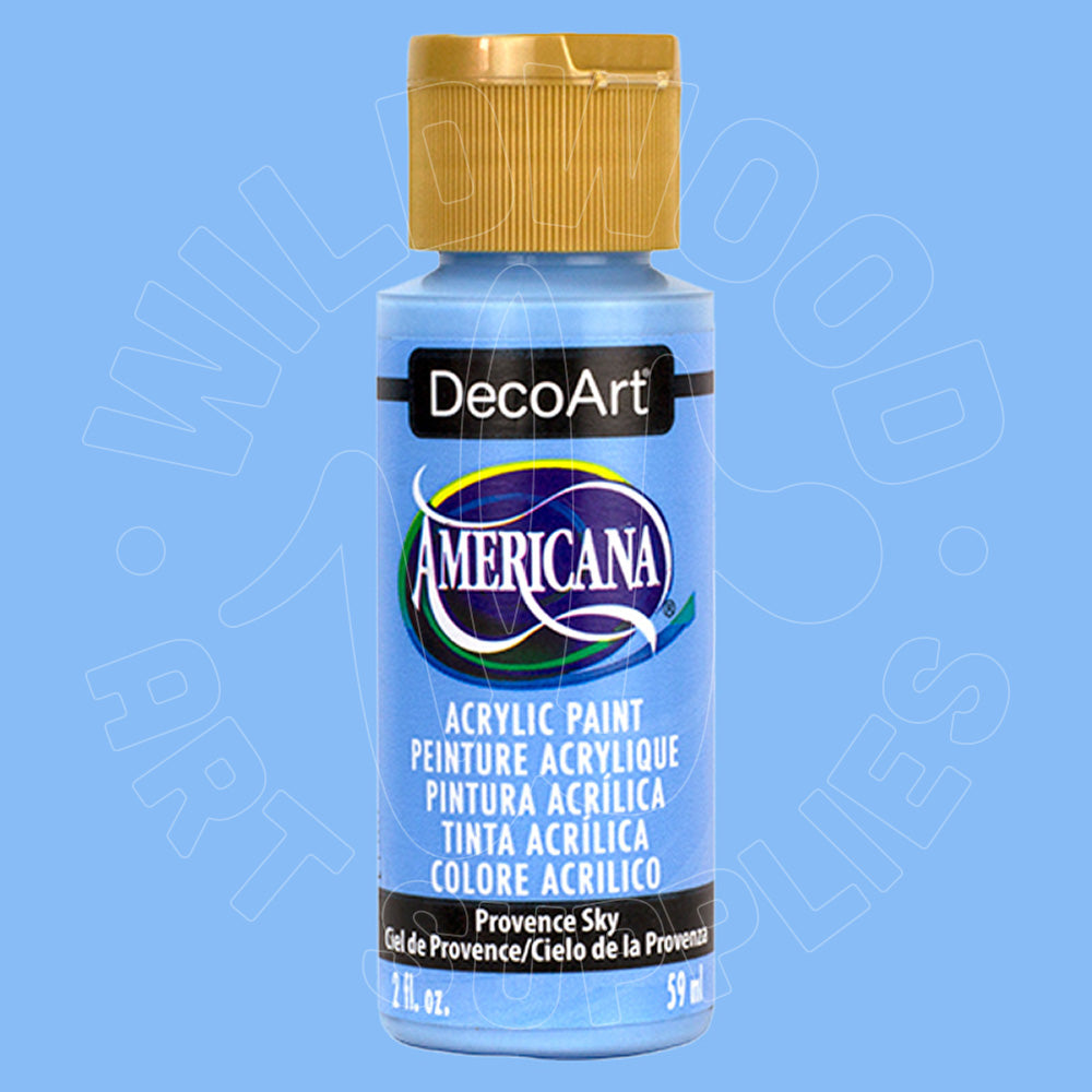 A bottle of DecoArt Americana acrylic paint in the color 'Provence Sky' (a light sky blue), featuring a gold cap and a blue label, set against a solid light blue background.