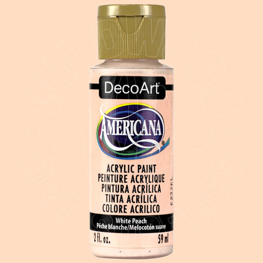 A bottle of DecoArt Americana acrylic paint in the color White Peach, featuring a gold cap and a white label with black text, set against a solid pale peach background.