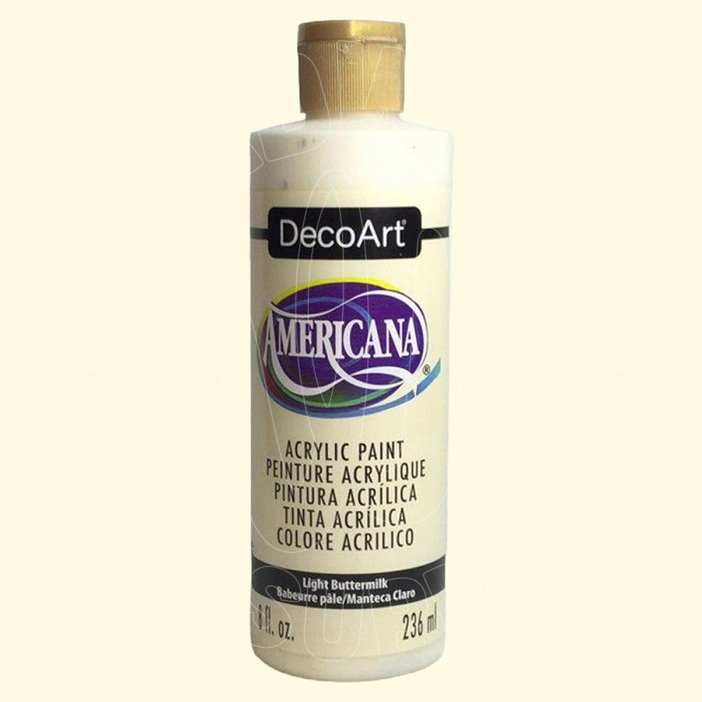 A bottle of DecoArt Americana acrylic paint in the color Light Buttermilk, featuring a cream-colored bottle with a gold cap and a purple and blue logo on the front label.