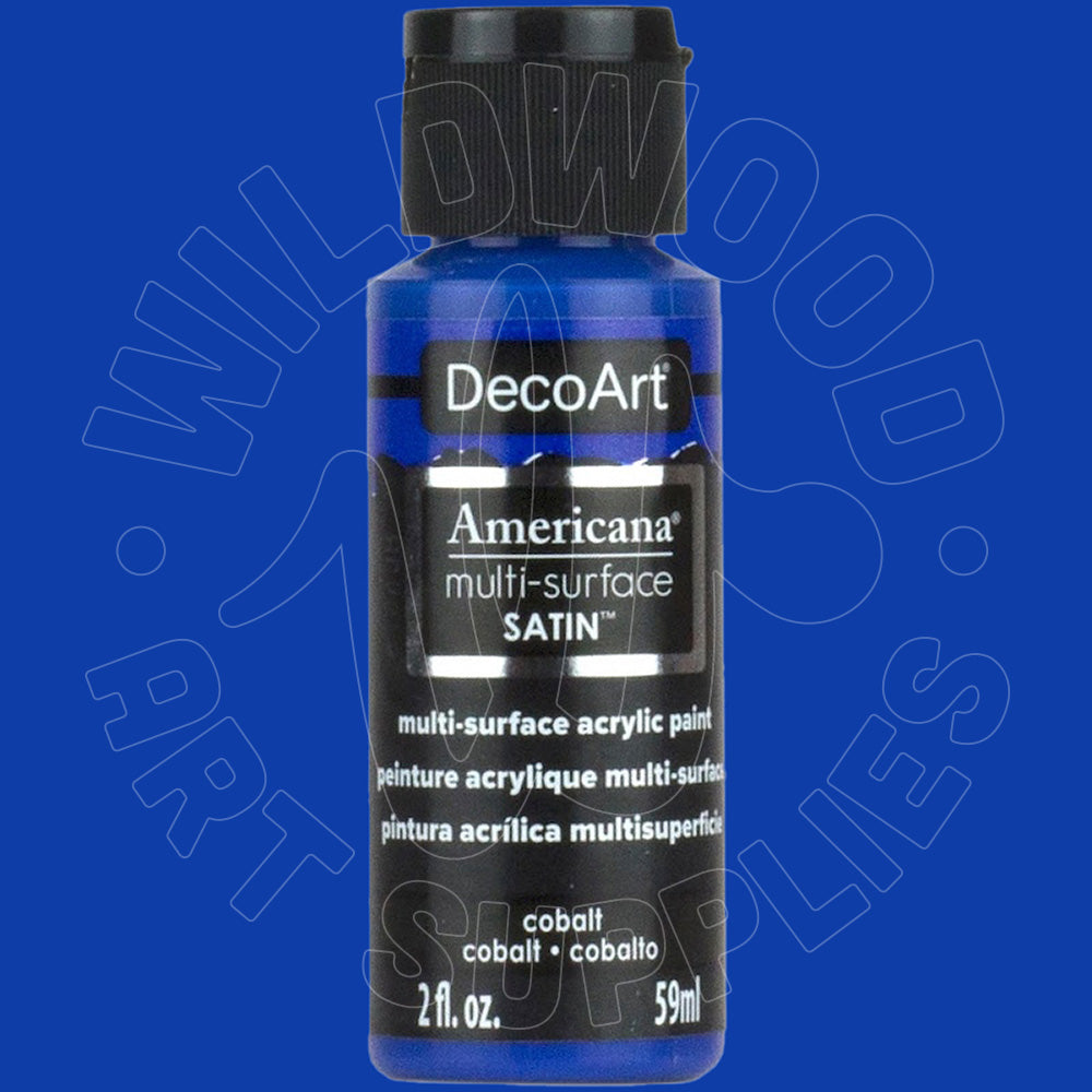 A bottle of DecoArt Americana multi-surface SATIN acrylic paint in cobalt blue, featuring a black cap and black label with white text, set against a solid blue background with a faint watermark.