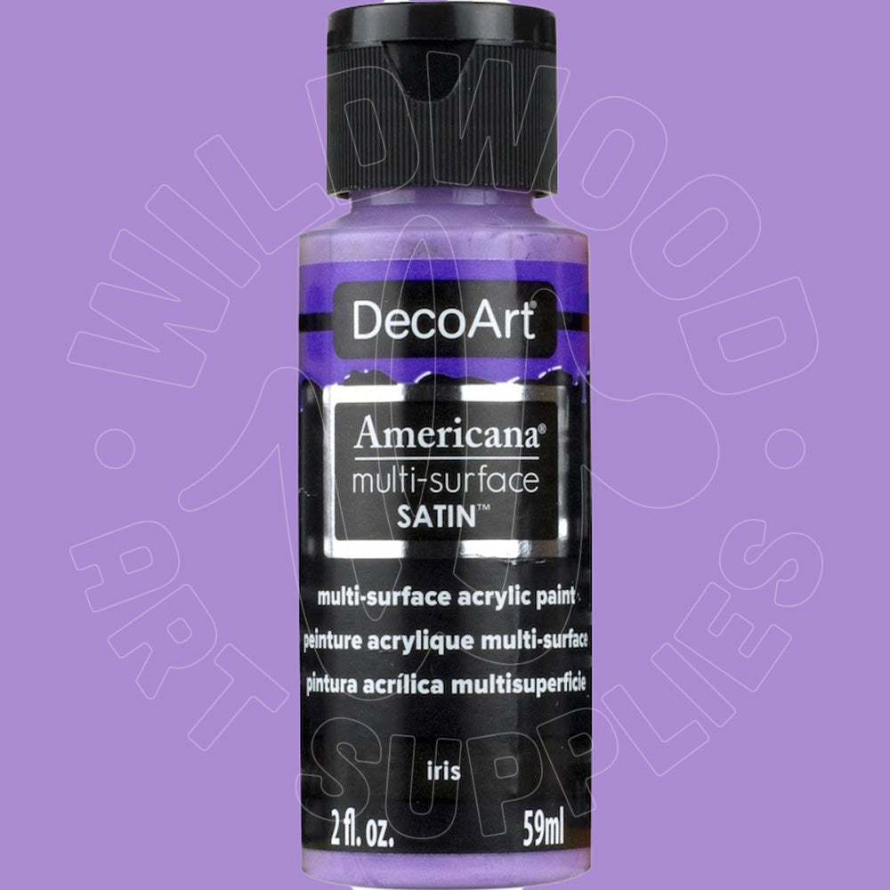 A bottle of DecoArt Americana multi-surface satin acrylic paint in the color 'iris', shown against a solid lavender-purple background. The bottle contains a light purple/lavender paint and has a black cap and black label.
