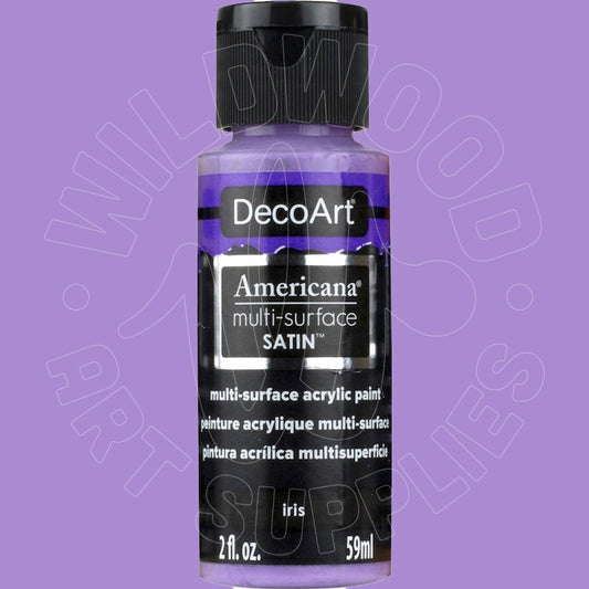 A bottle of DecoArt Americana multi-surface satin acrylic paint in the color 'iris', shown against a solid lavender-purple background. The bottle contains a light purple/lavender paint and has a black cap and black label.