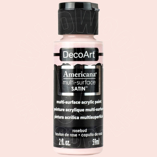 A bottle of DecoArt Americana multi-surface satin acrylic paint in the shade 'rosebud', featuring a black cap and black label with white text, set against a solid pale pink background.