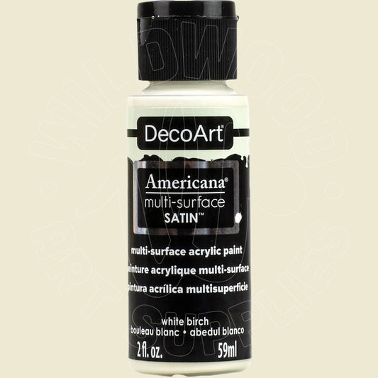 A bottle of DecoArt Americana multi-surface satin acrylic paint in the color white birch, featuring a black cap and black label with white text, set against a solid light beige background.
