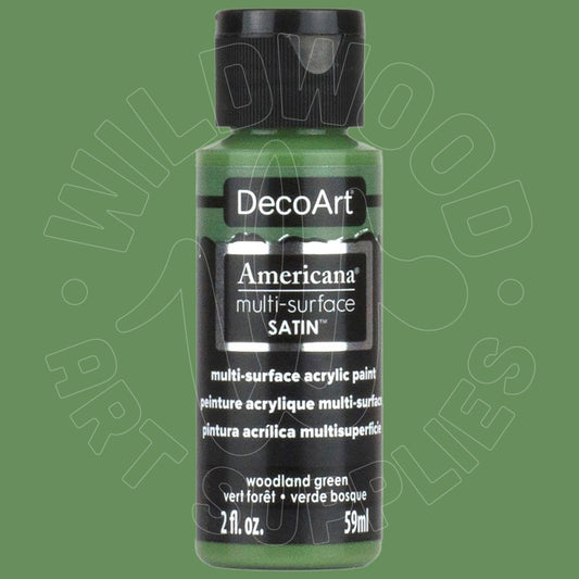 A bottle of DecoArt Americana multi-surface SATIN acrylic paint in the color 'woodland green', featuring a black cap and black label on a solid green background.